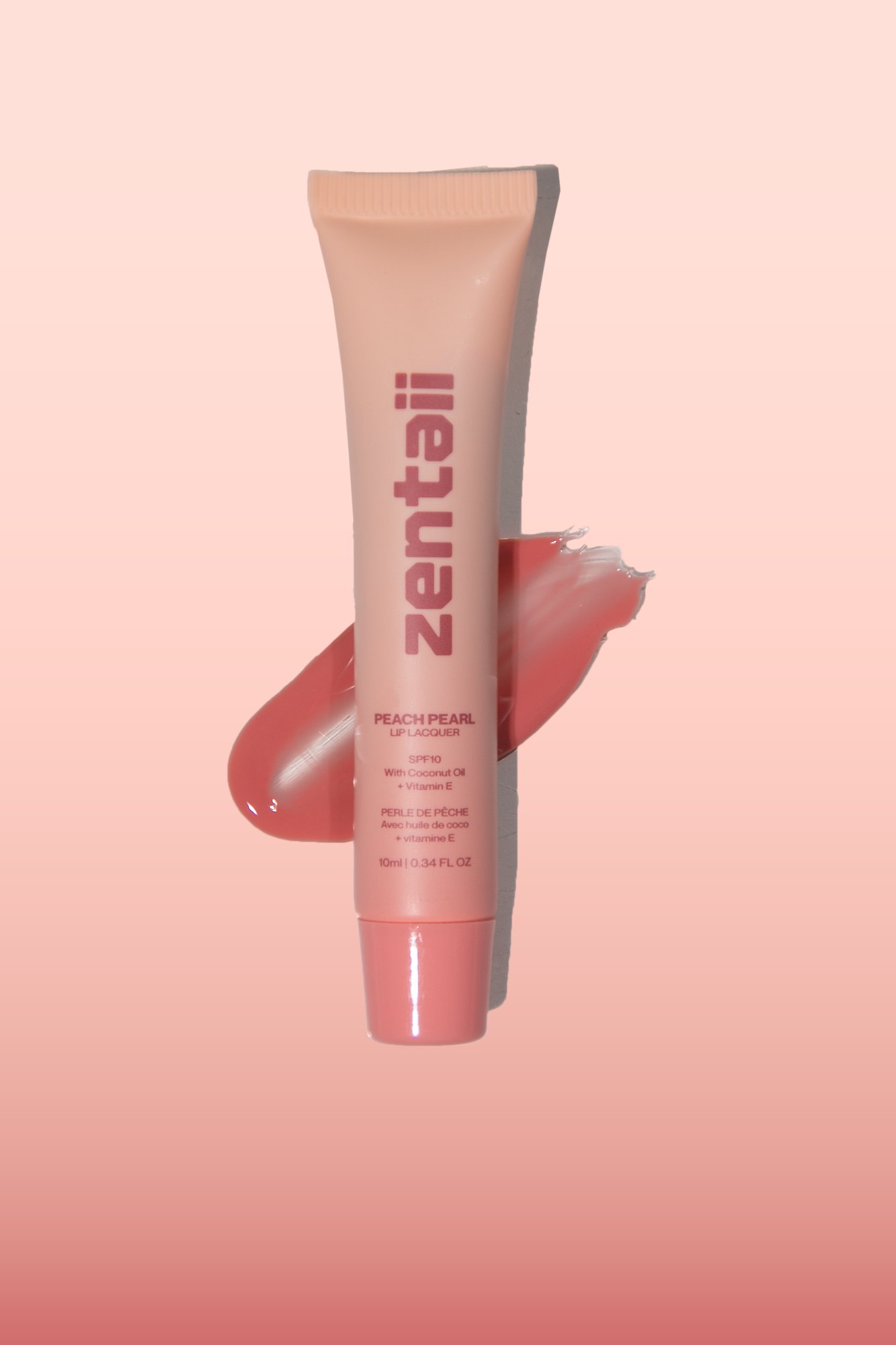A pink lip tube on a soft pink ground with a glossy swatch of the shade beside it.